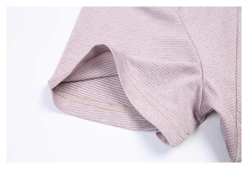 Close-up of a pale mauve patterned garment hem, showing the folded edge and overlock stitching.