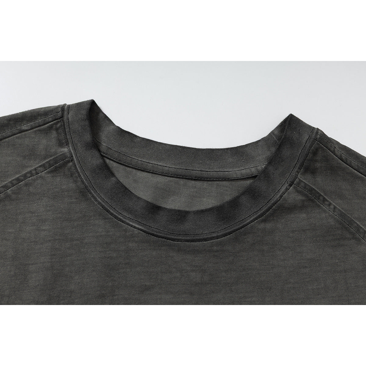Close-up of the crew neckline and shoulder seams on a washed charcoal sleeveless top.