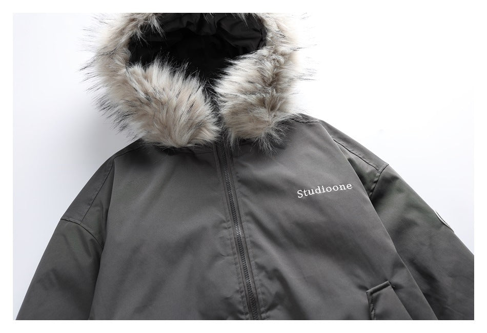 Close-up of the charcoal jacket's fur-trimmed hood, front zipper, and chest lettering.