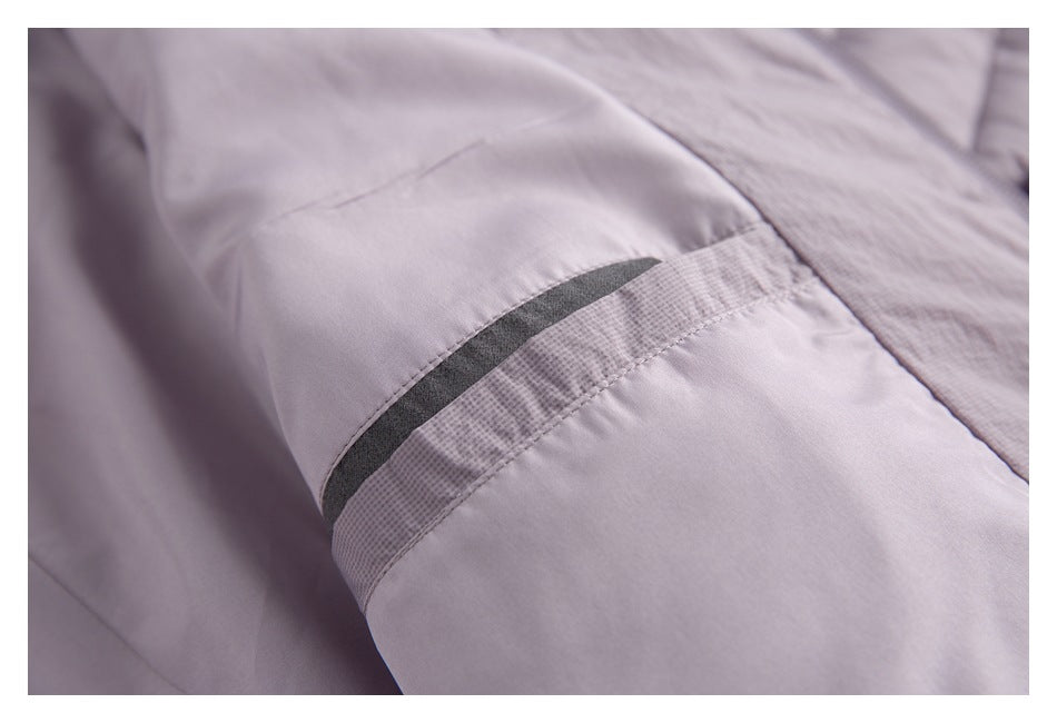 Close-up of a jacket sleeve showing a dark narrow trim detail across the mauve-gray fabric.