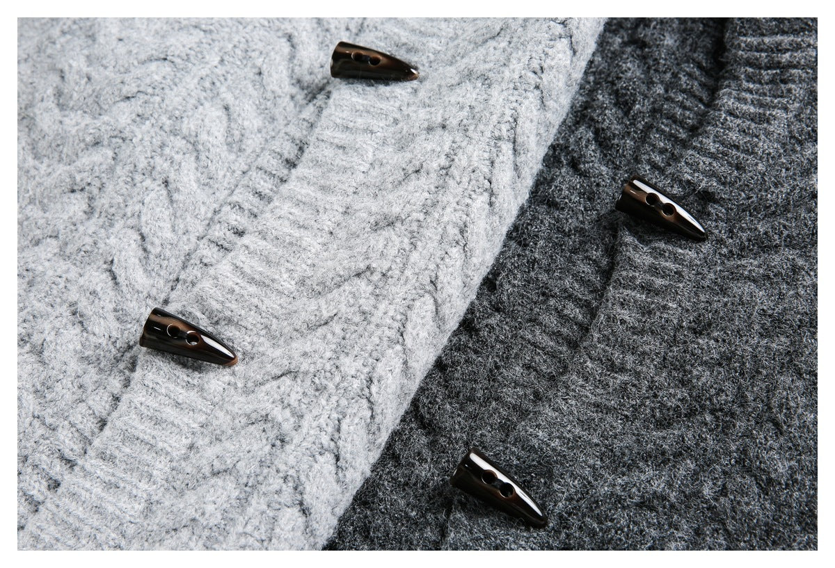 Close-up of light gray and charcoal cable-knit sweater fronts with dark toggle buttons.