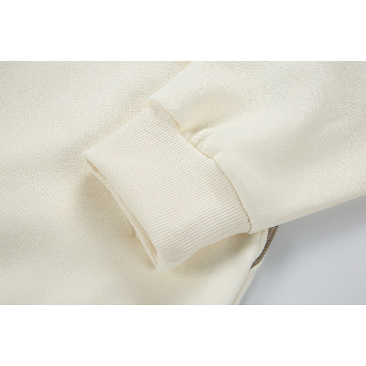 Close-up of an ivory jacket sleeve with a wide ribbed cuff.
