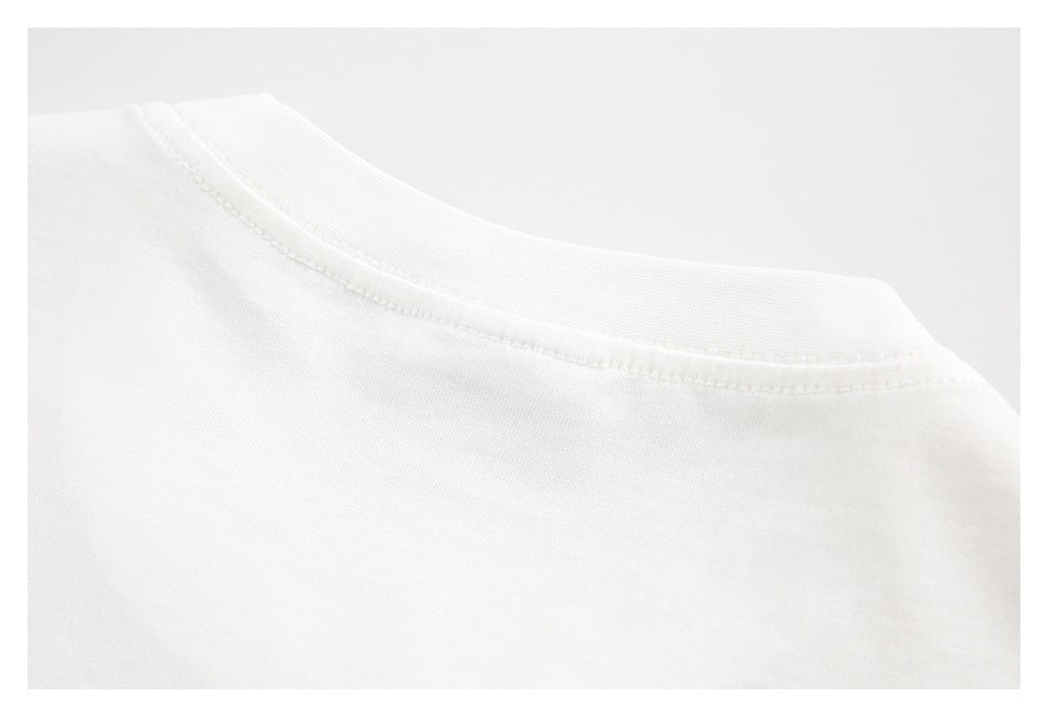 Close-up of the crew neckline and stitching on a white garment.