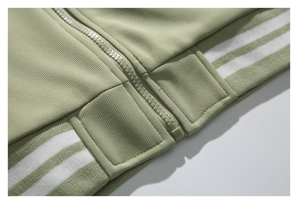 Close-up of the jacket's front zipper and striped ribbed hem in pale sage and white.