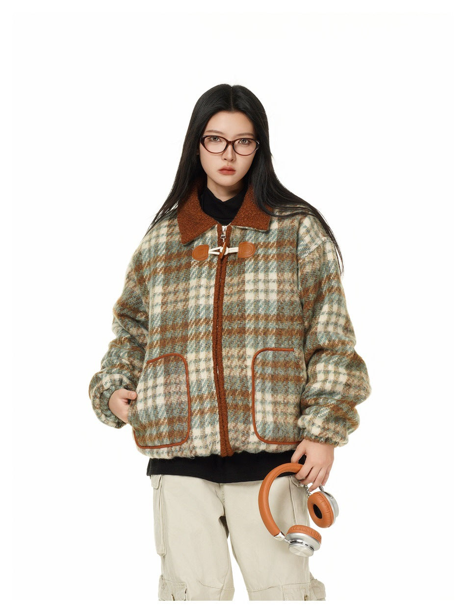 Model wearing the plaid jacket with black top and beige cargo pants, one hand in pocket, holding orange headphones