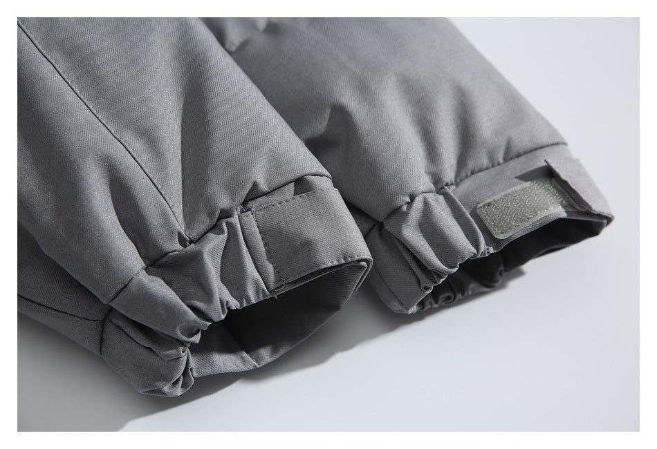 Close-up of gray jacket cuffs with gathered edges and adjustable hook-and-loop tabs.
