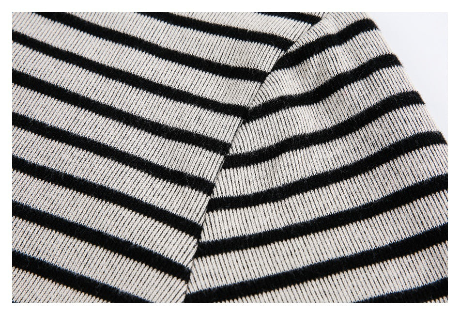 Close-up of the striped fabric and shoulder seam on a cream-and-black garment.