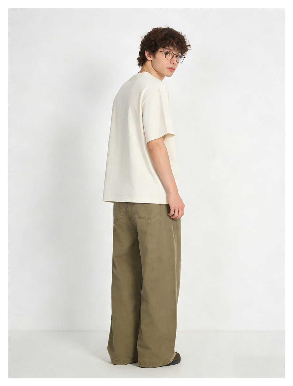 Model shown from behind in an off-white short-sleeve T-shirt and loose olive-brown trousers.