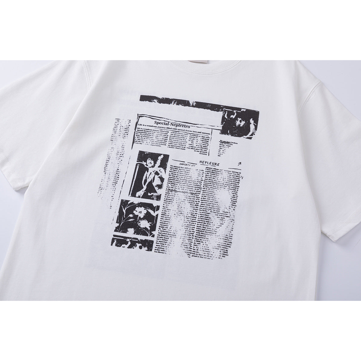 Close-up of a white T-shirt with a black newspaper-style graphic and small images printed on the chest.