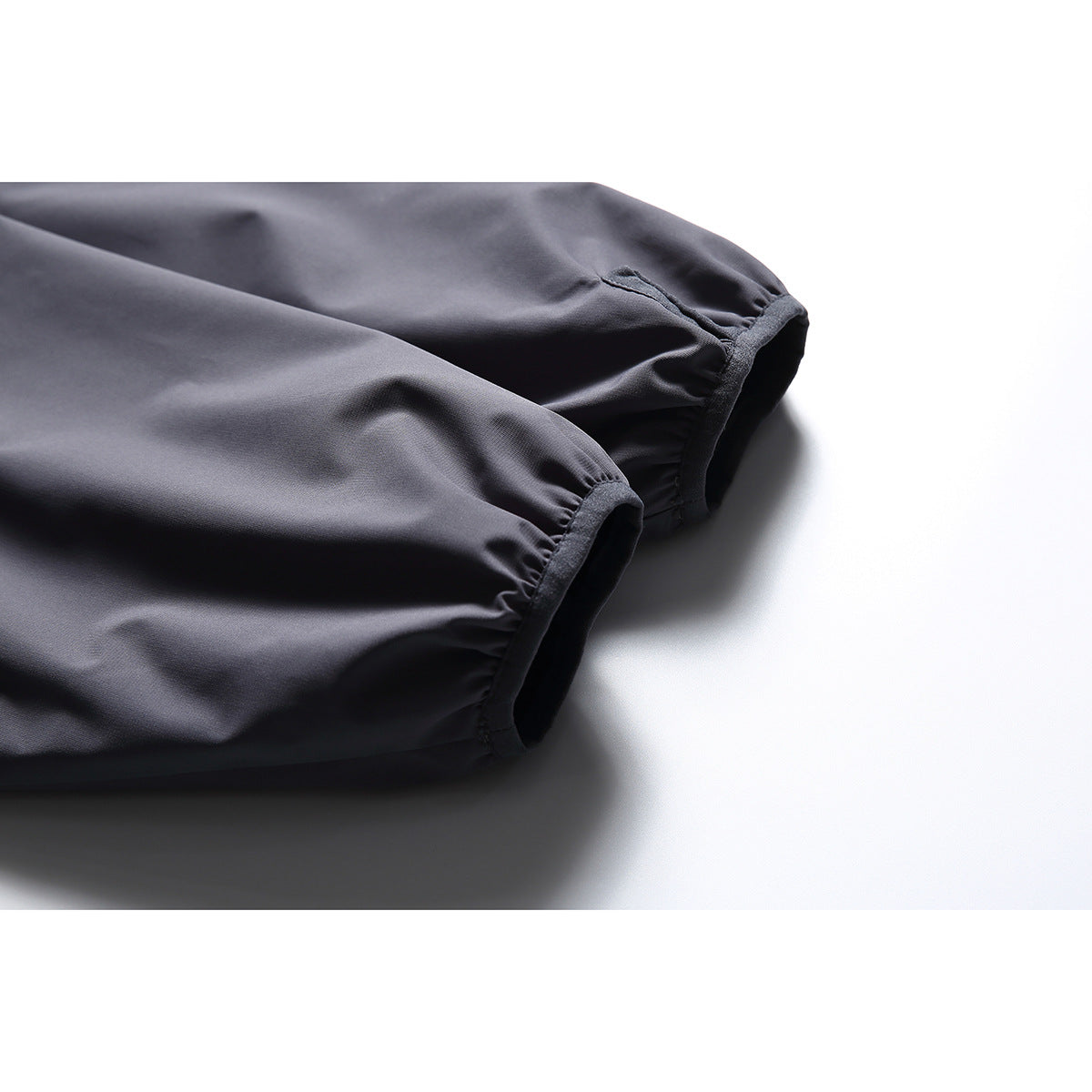Close-up of two gathered sleeve cuffs on the charcoal-gray jacket.