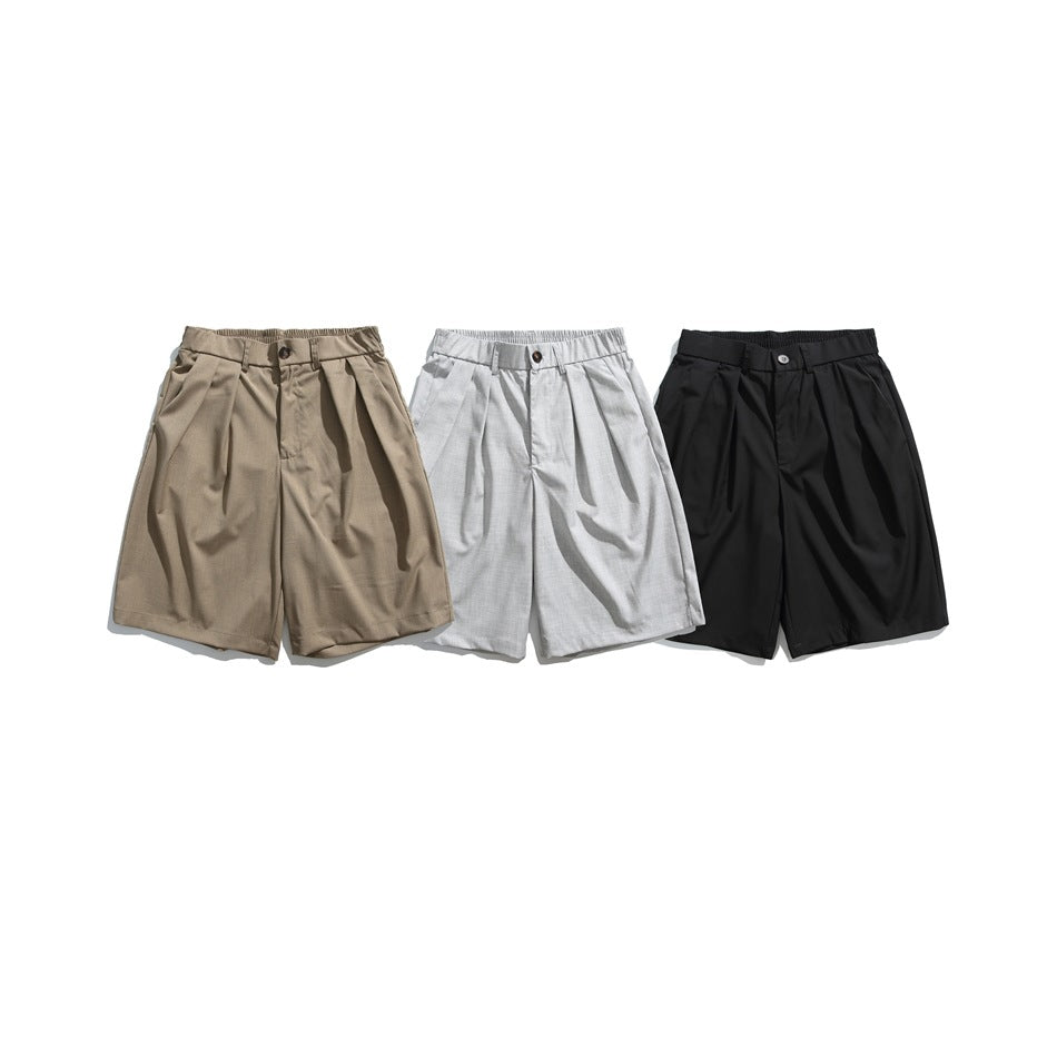 Three pairs of pleated shorts shown from the front in taupe, light gray, and black.
