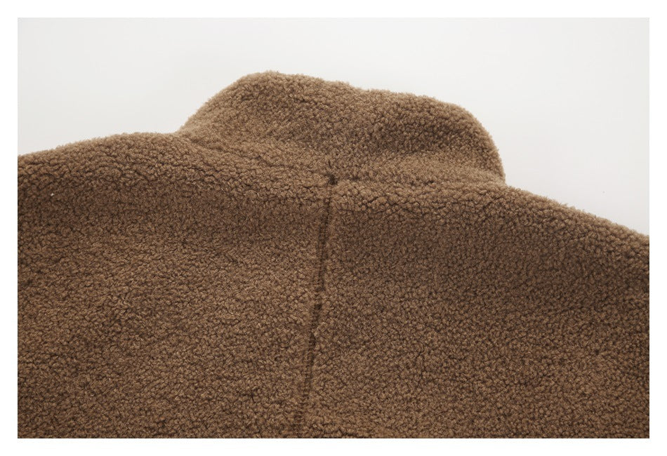 Close-up of the raised collar and seam on a brown curly-textured jacket.