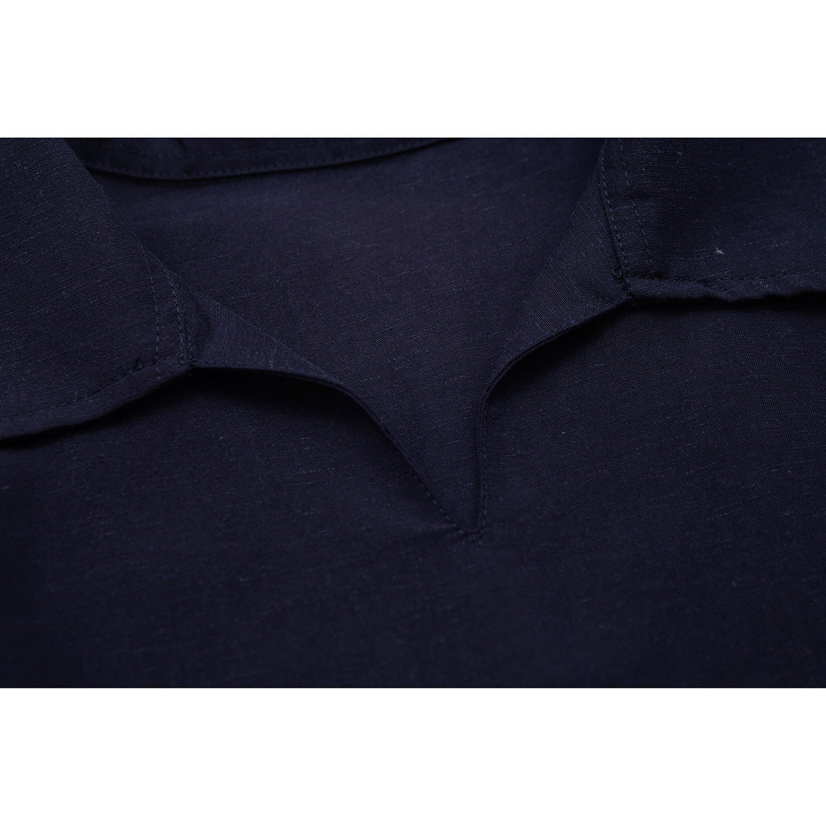 Close-up of the dark navy polo shirt's collar and neckline stitching.