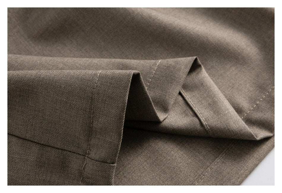 Close-up of a folded taupe-brown trouser leg showing the hem and stitching.