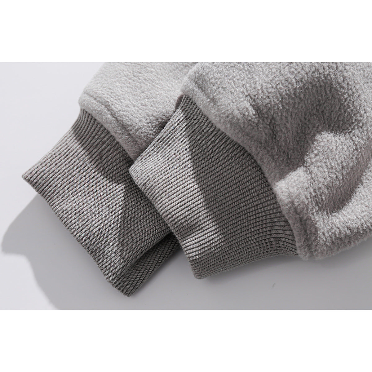 Close-up of light-gray fleece sleeves and ribbed cuffs.