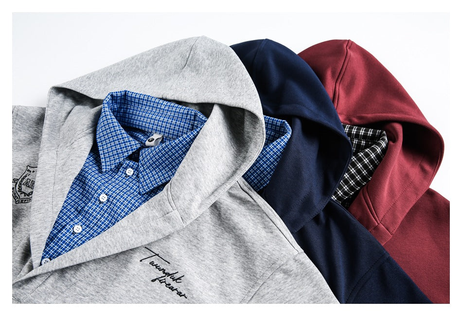 Close-up of gray, navy, and burgundy hooded tops layered to show checked shirt collars and garment details.
