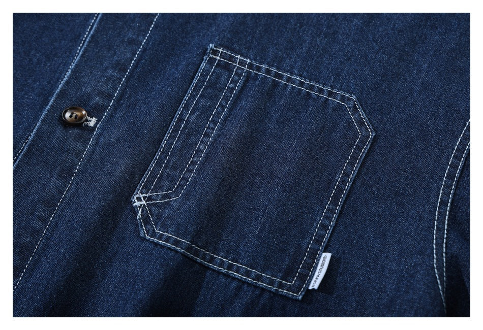 Close-up of a dark indigo denim shirt's chest pocket, contrasting stitching, and small side label.