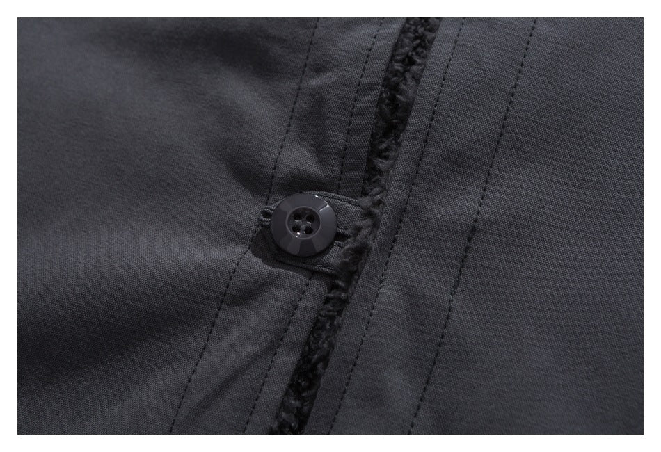 Close-up of a black button and stitched placket beside a narrow strip of dark plush lining.