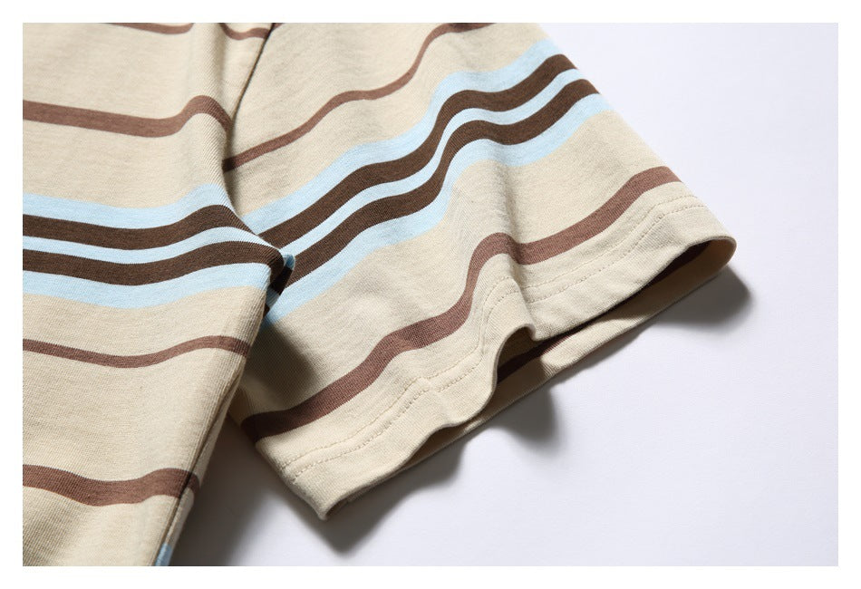 Close-up of the short sleeve and stitched hem on a beige T-shirt with brown and pale blue stripes.