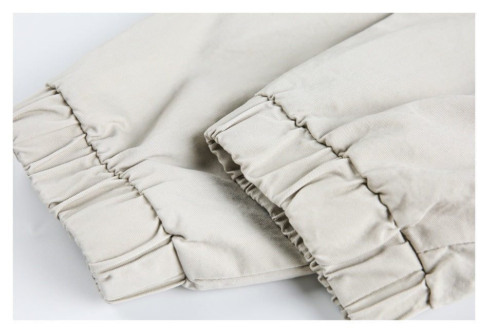 Close-up of gathered, stitched edges on cream fabric, showing the garment's construction.