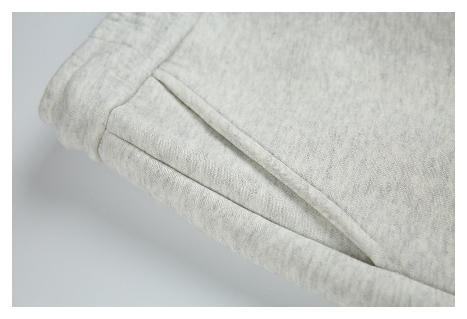 Close-up of a slanted pocket opening and seam on light gray marl sweatpants.