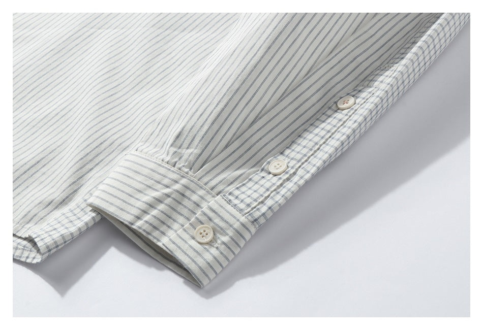 Close-up of a striped shirt sleeve and cuff with cream buttons and checked trim.