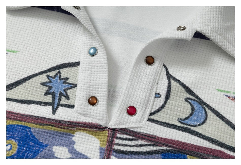 Close-up of the polo's textured fabric, contrasting colored snaps, and star and moon graphics.
