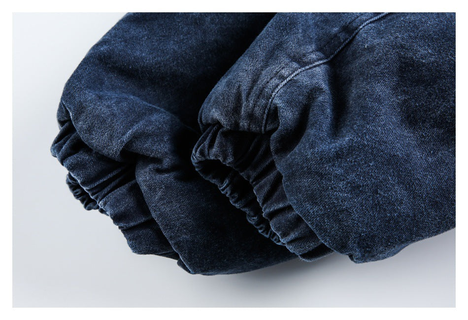 Close-up of a dark blue garment with gathered, stitched fabric folds.