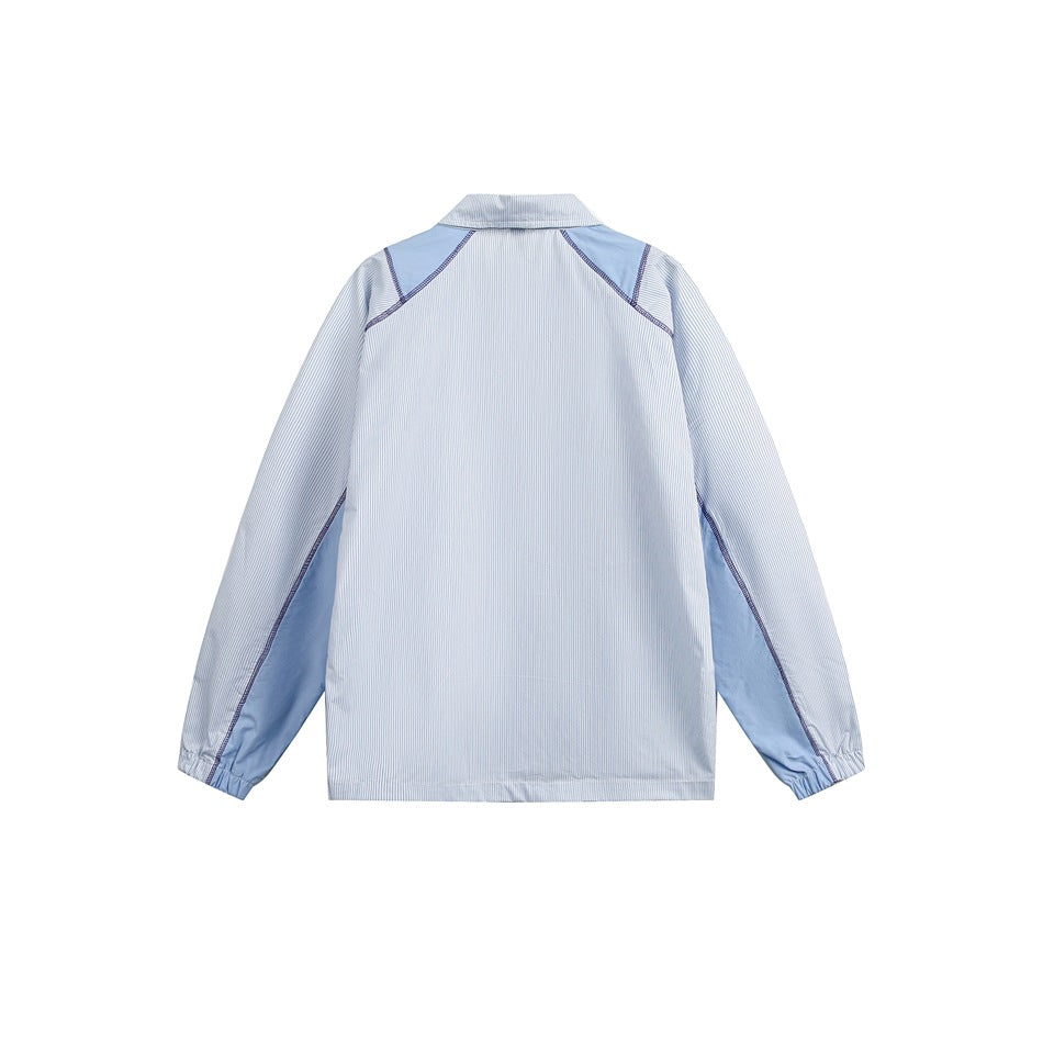 Back view of light blue striped jacket with blue shoulder and underarm panels, contrast stitching and elastic cuffs