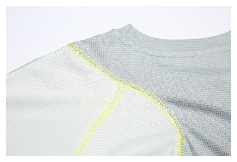 Close-up of the light gray shirt neckline and shoulder, with white panels and neon-yellow overlock seams.