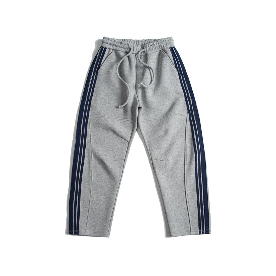 Heather gray sweatpants with navy triple side stripes and drawstring elastic waist, flat lay front view