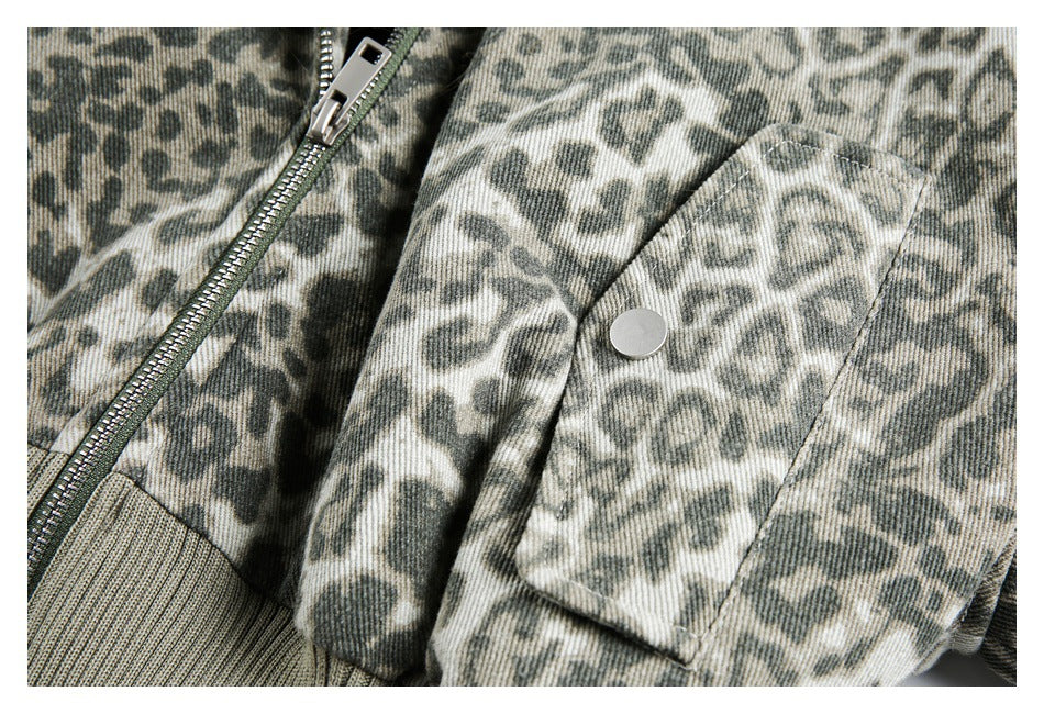 Close-up of an animal-print jacket pocket with a silver snap, zipper, and ribbed cuff.