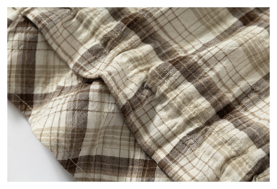 Close-up of the beige and brown plaid fabric gathered into soft folds.