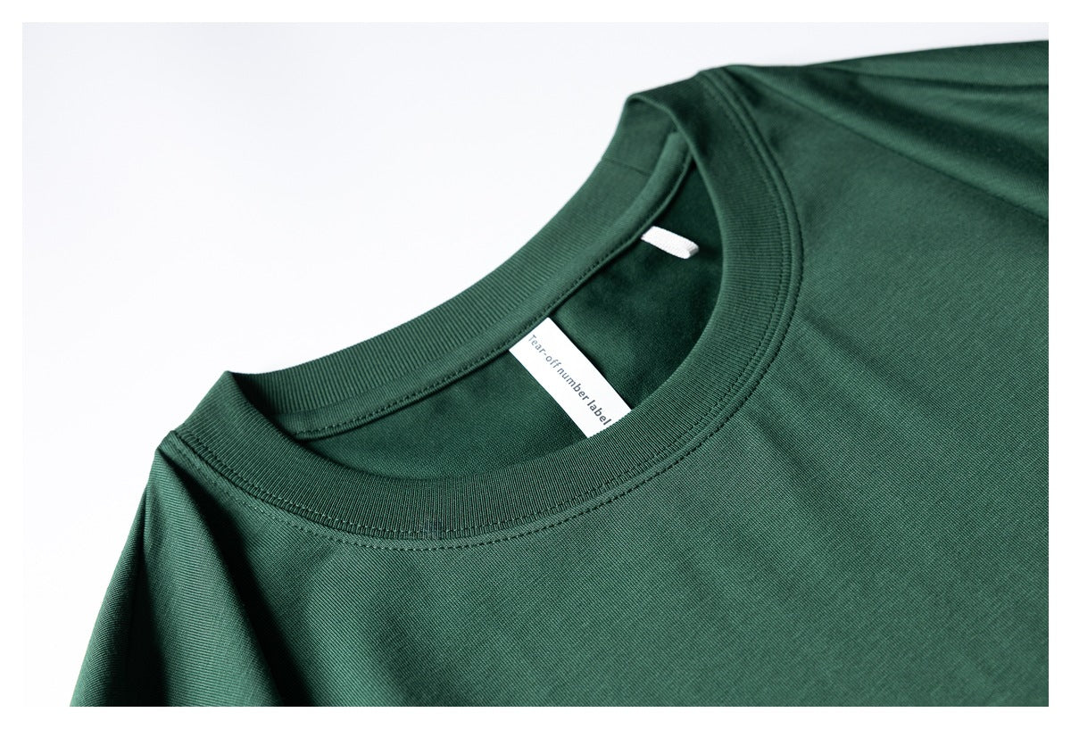 Close-up of a dark green T-shirt's ribbed crew neckline and inner neck label.