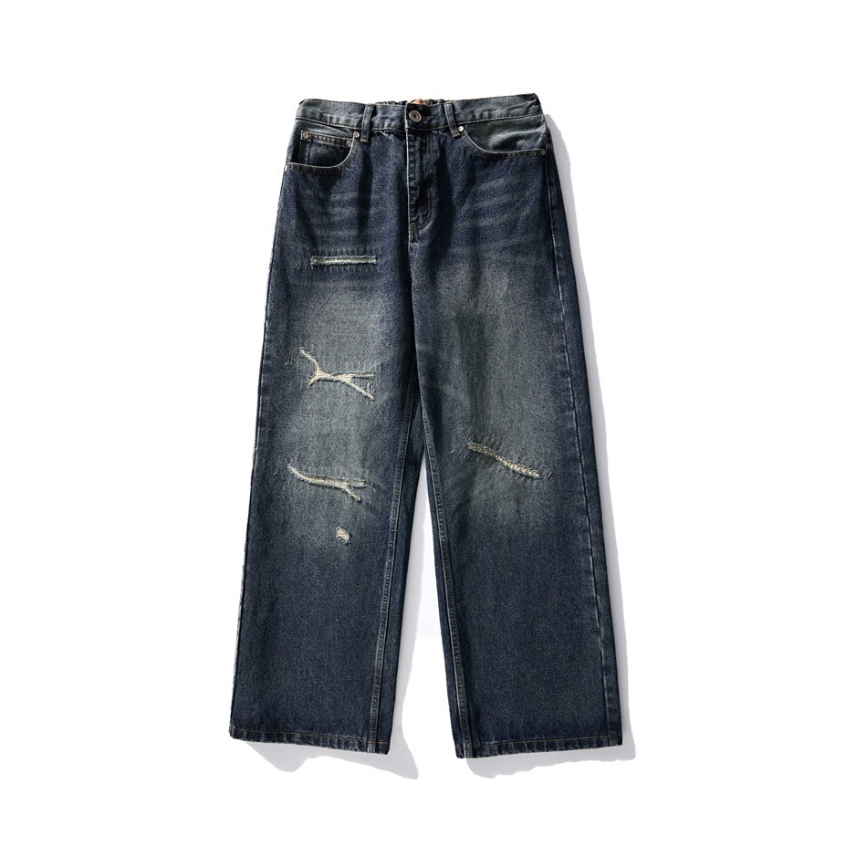 Front view of dark blue washed wide-leg jeans with distressed slits and stitched patch repairs