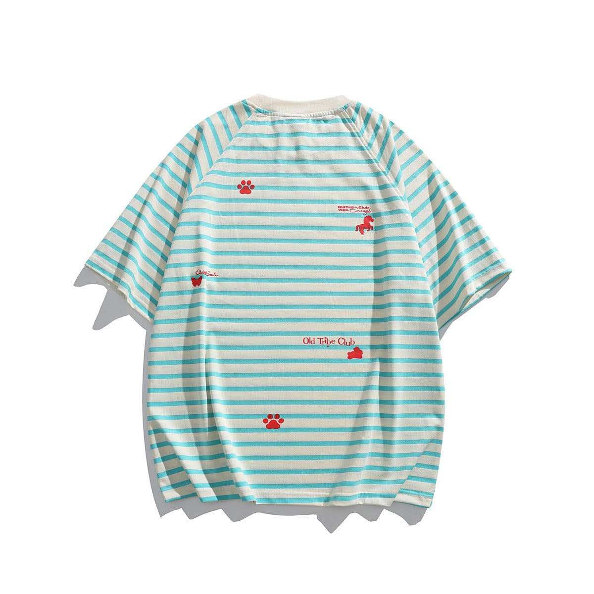 Flat-lay view of an off-white short-sleeve shirt with turquoise stripes and scattered red paw, animal and text motifs.
