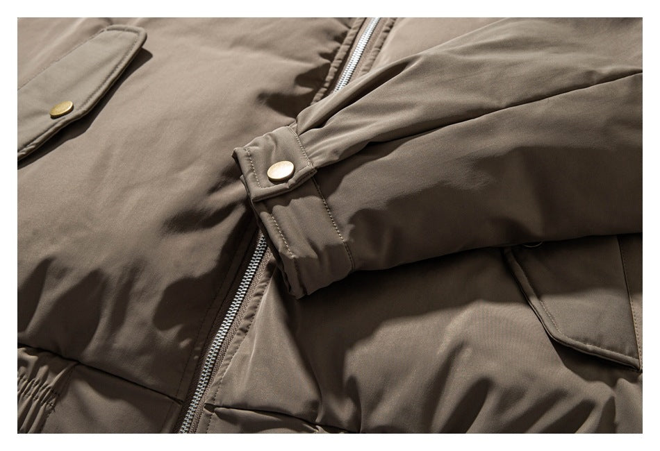 Close-up of the taupe jacket's sleeve snap cuff, front zipper, and flap pockets.