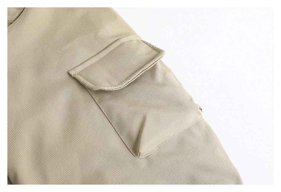 Close-up of a flap pocket and fine ribbed fabric on the beige jacket.
