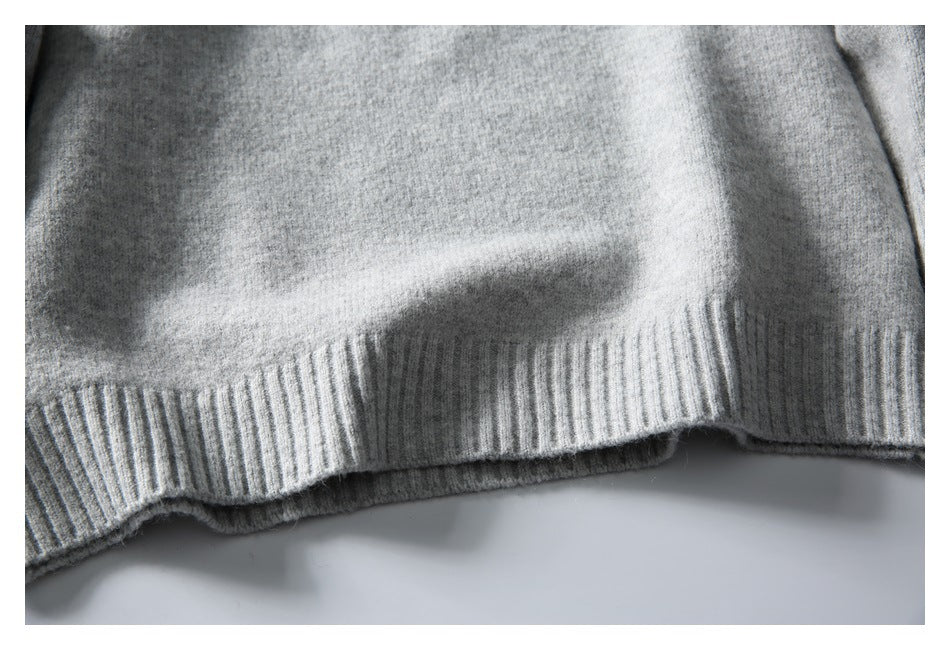 Close-up of the light gray knit sweater's ribbed hem.