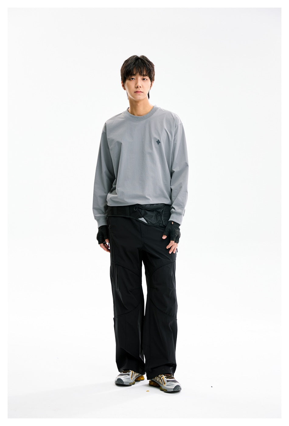 Model wearing the gray long-sleeve crew-neck top with black pants, front standing view