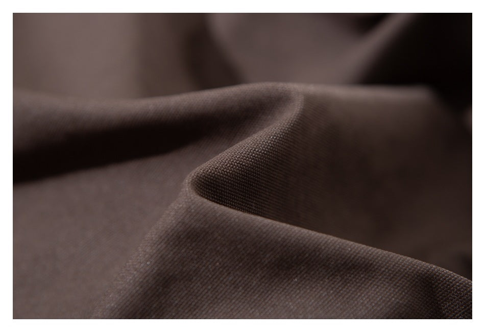 Macro view of dark brown fabric, showing its fine texture and soft folds.