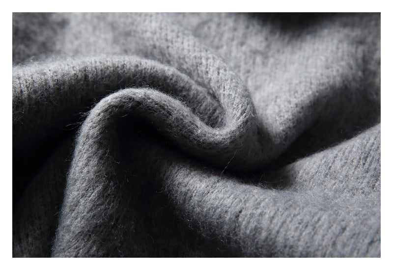 Macro view of softly folded gray knit fabric showing its fuzzy surface texture.