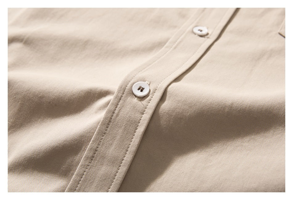 Close-up of the beige shirt's front placket with two white buttons and visible stitching.