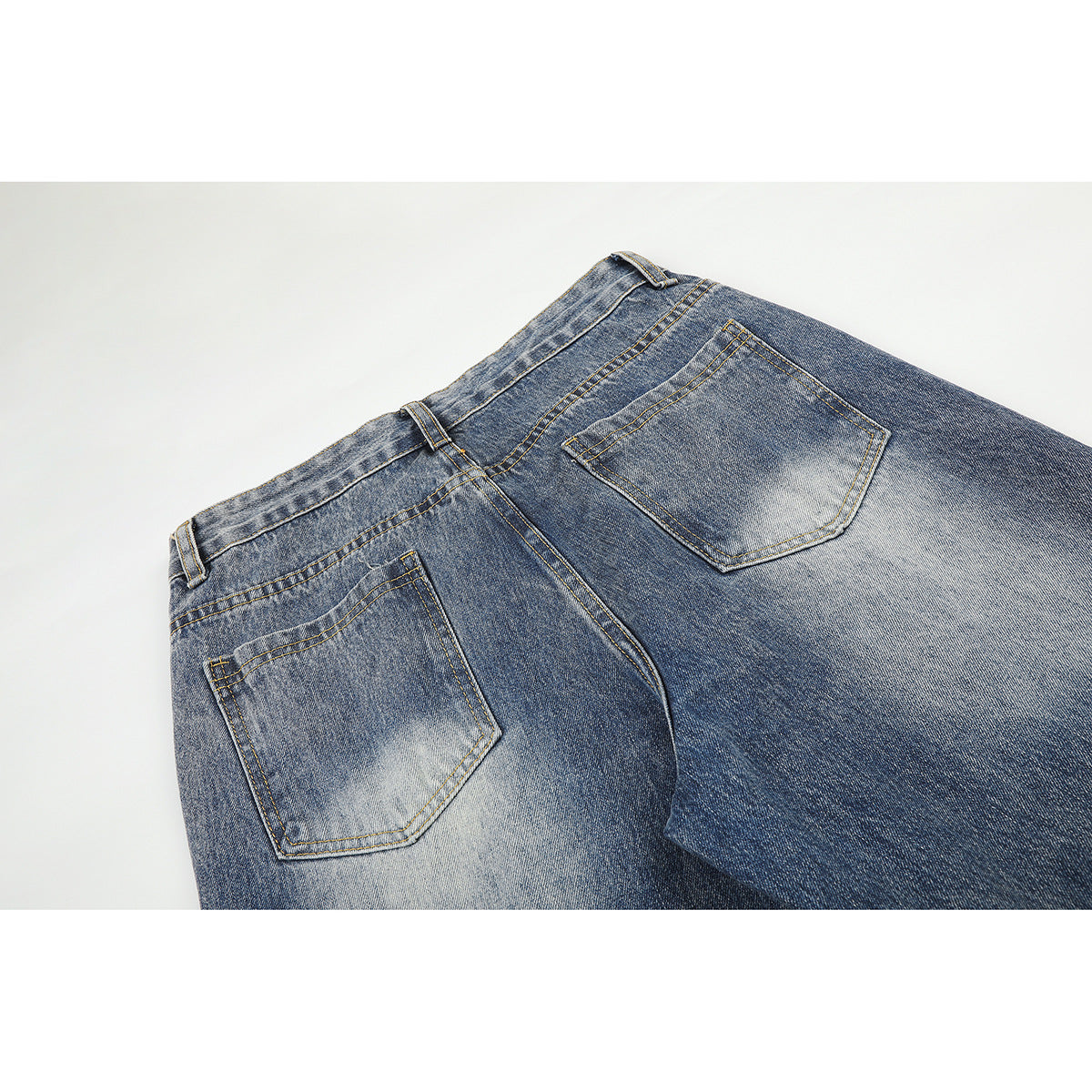 Close-up of the back waistband and two pockets on blue acid-wash jeans.