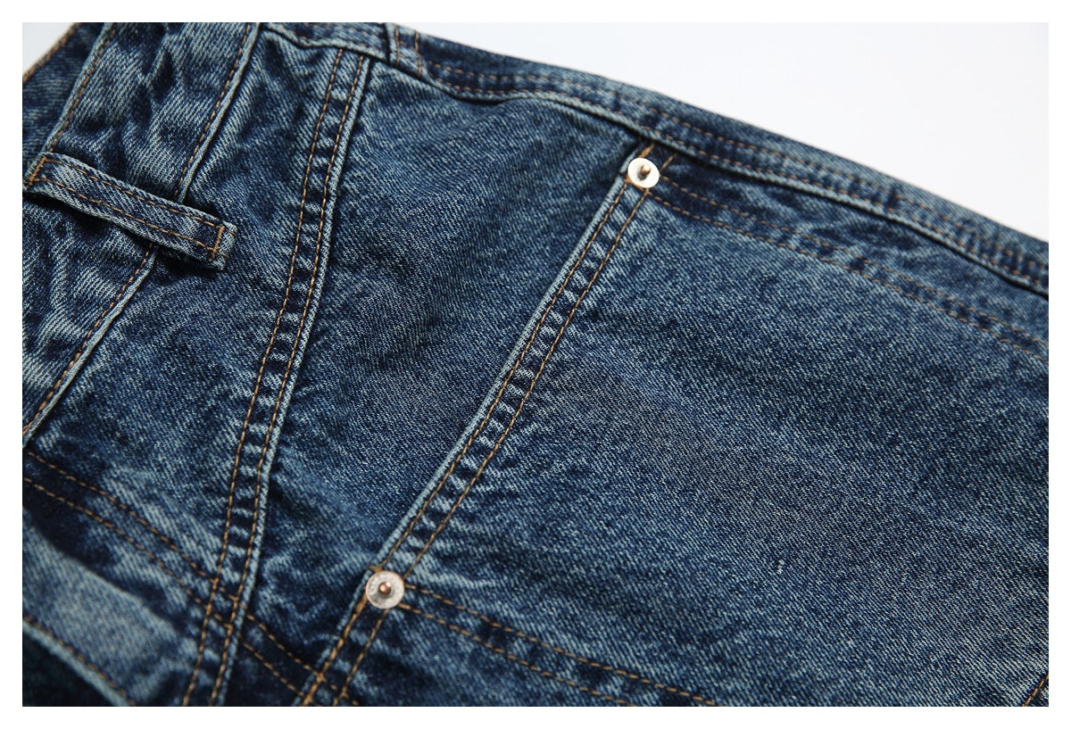 Close-up of a blue jeans panel with contrast stitching, seams, and metal rivets.