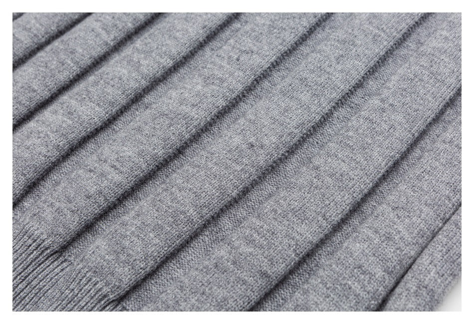 Close-up of gray knit garment fabric arranged in diagonal folds.