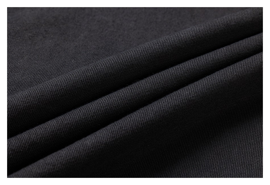 Close-up of black fabric folded to show its fine ribbed texture.