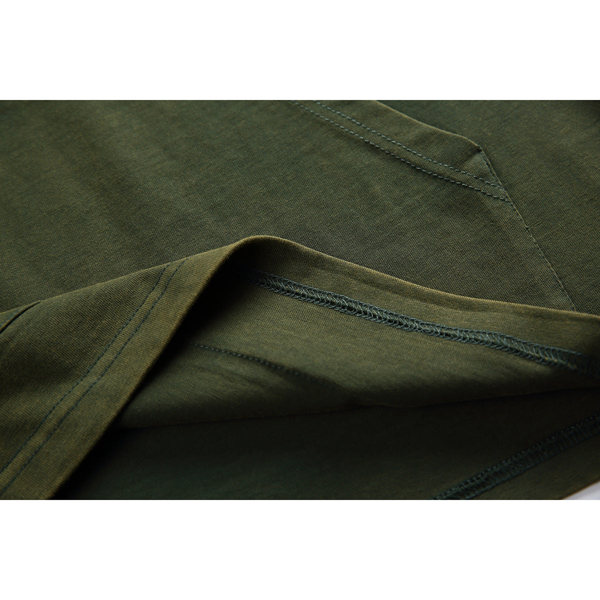 Close-up of olive garment fabric folded to show the stitched, overlocked inside seam.