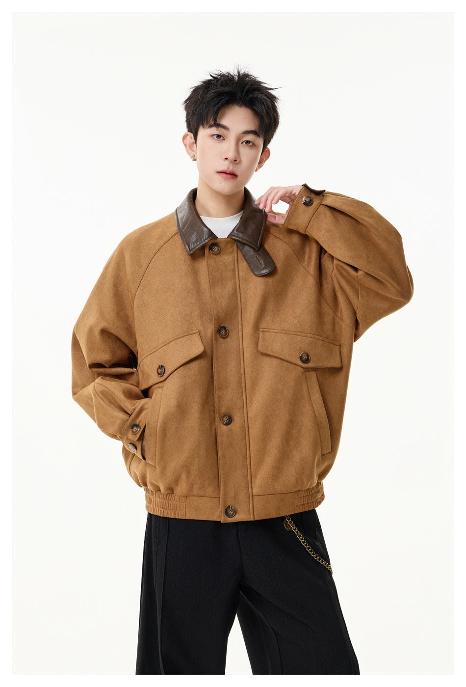 Front view of a model wearing an oversized camel-brown jacket with a dark brown collar and buttoned flap pockets.