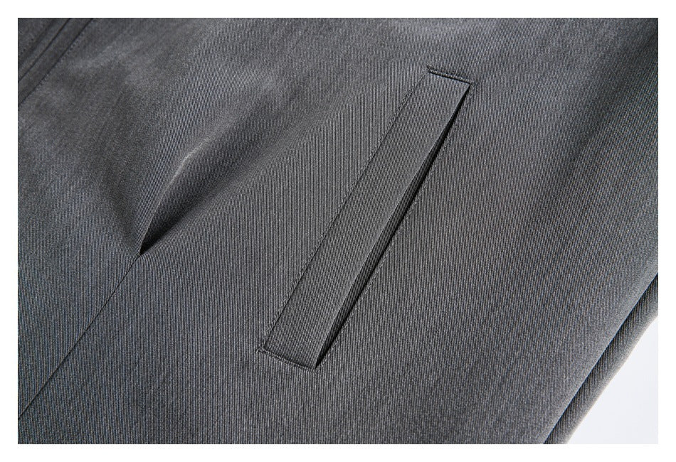 Close-up of a narrow welt pocket on gray jacket fabric.